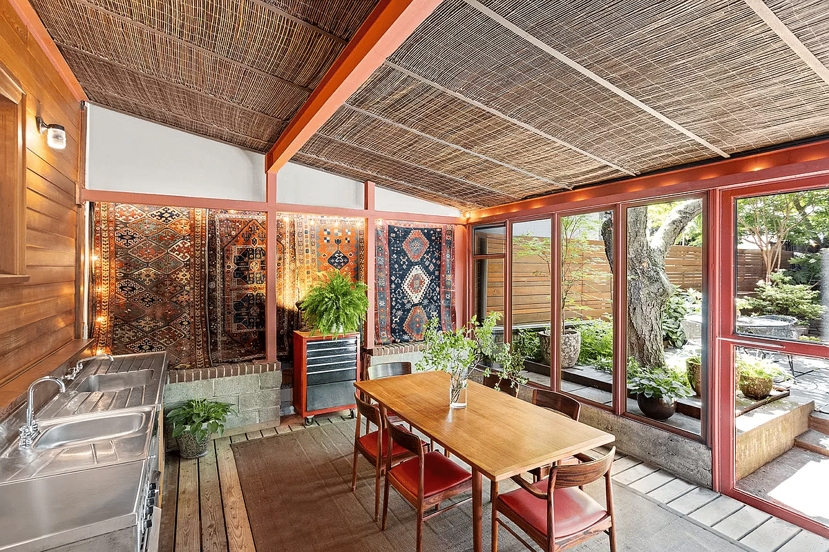 an enclosed rear porch with an outdoor kitchen and wood decking for the floor