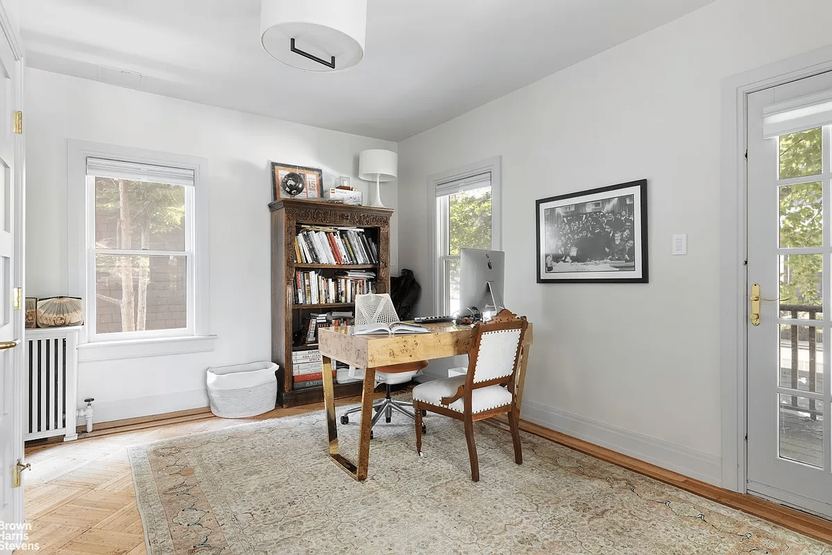 bedroom set up as an office with door to a balcony