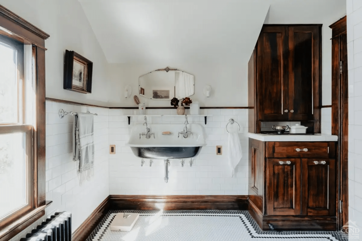 bathroom with wall mounted sink, black and white floor tile