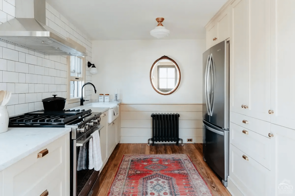 kitchen with horizontal wainscoting, apron front sink, and painted cabinets with bin pulls