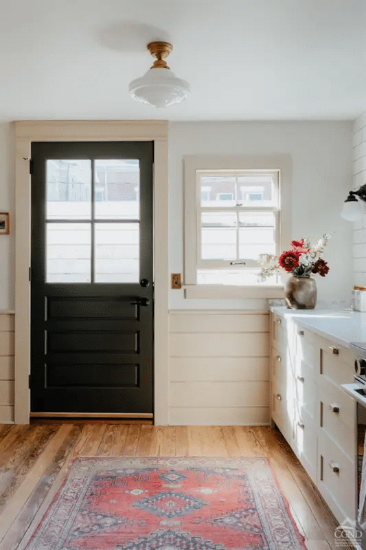 kitchen with horizontal wainscoting and a rear door to the garden