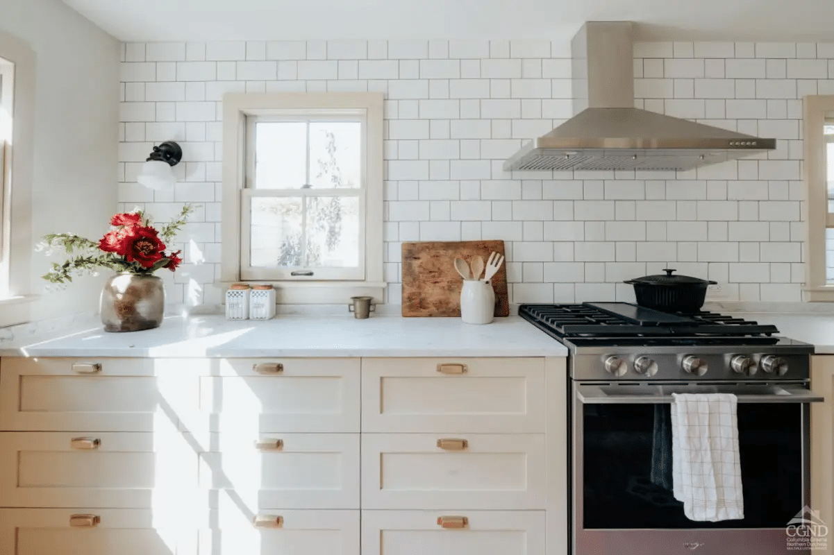 kitchen with horizontal wainscoting, apron front sink, and painted cabinets with bin pulls