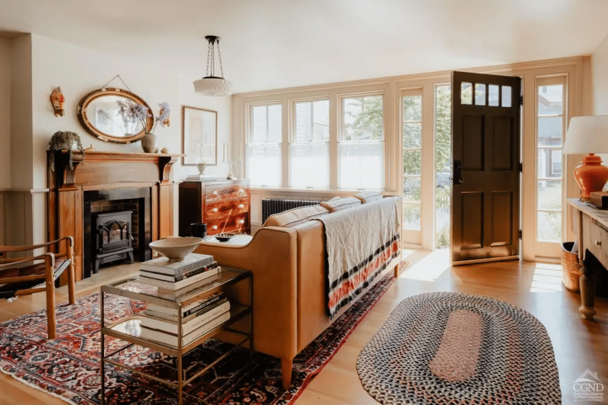 front door open to the living room with wood floors, mantel