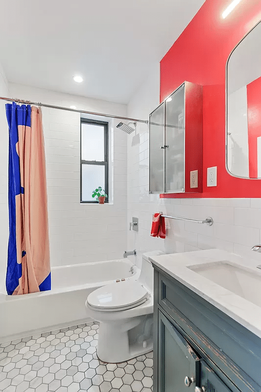 bathroom with white fixtures, wood vanity, hex tile floor