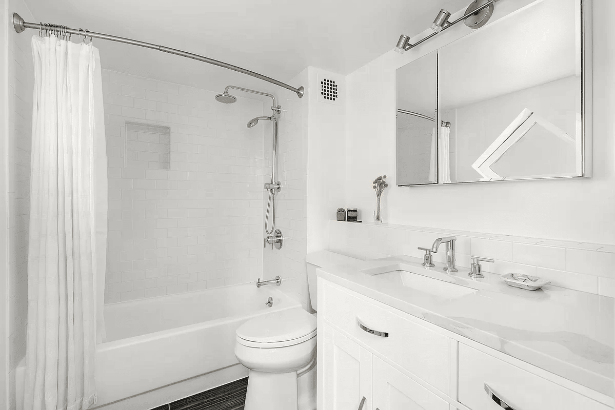 Bathroom with white fixtures, including a bathtub