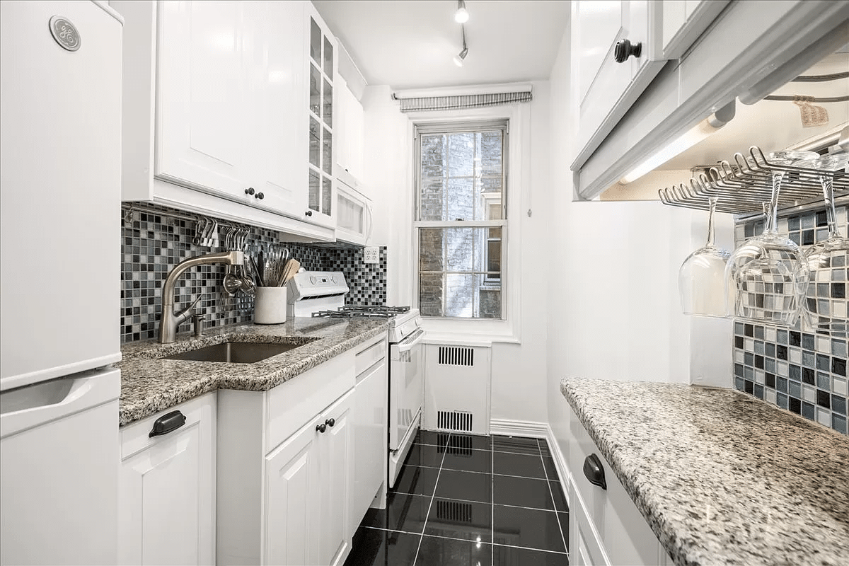 kitchen with black floor tile, white cabinets