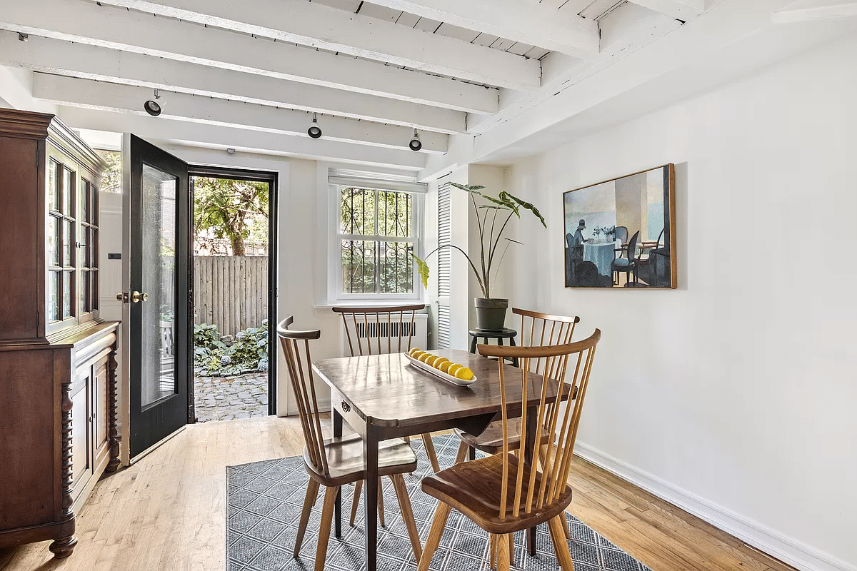 dining room with exposed beams, wood floor