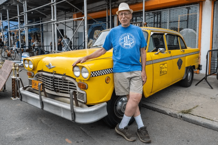 man posing in front of a taxi