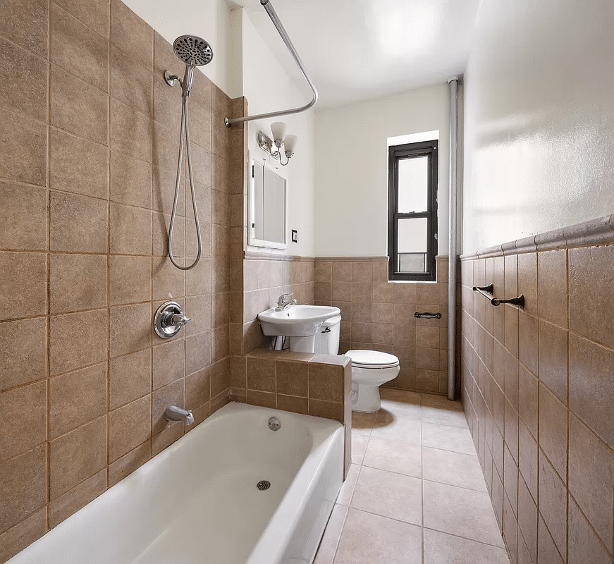 bathroom with beige wall and floor tile and white fixtures