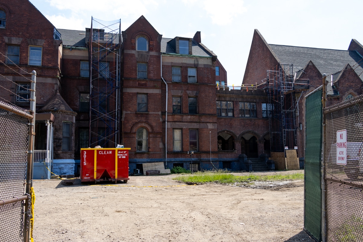 a dumpster and scaffolding on the grounds of the school