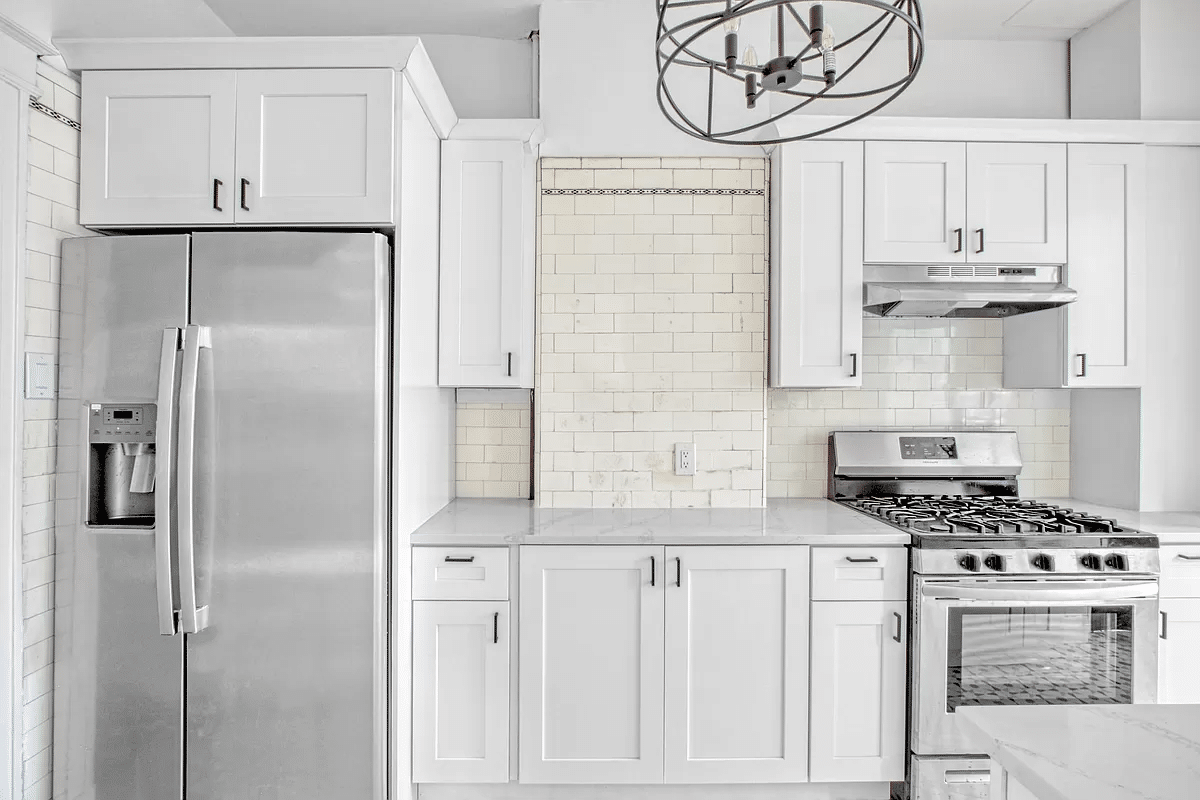 kitchen with white cabinets, marble counters