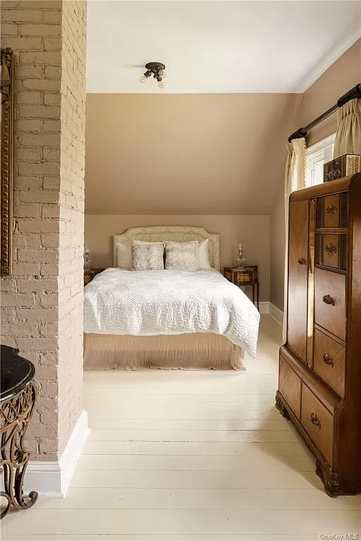 bedroom with painted wood floor, exposed and painted brick wall