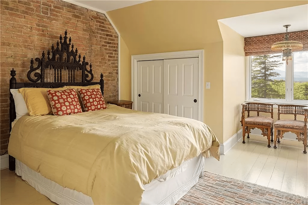 bedroom with painted wood floor, exposed brick wall