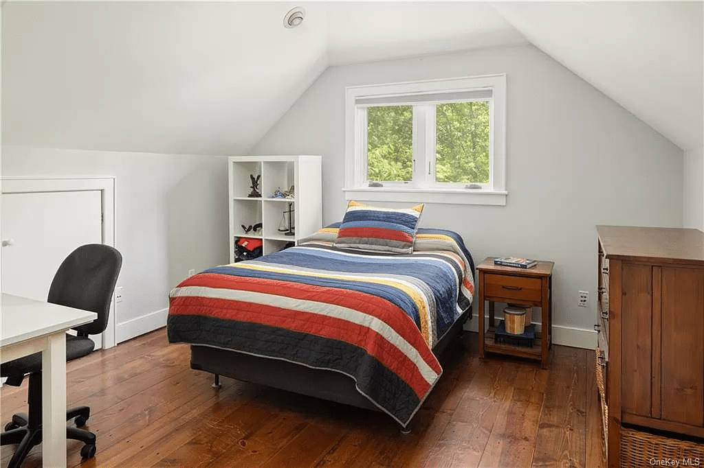 bedroom in the guest cottage with sloping ceiling and wood floors