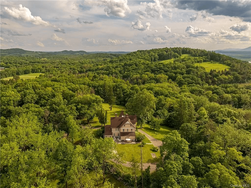 aerial view showing house surrounded by a lawn and trees