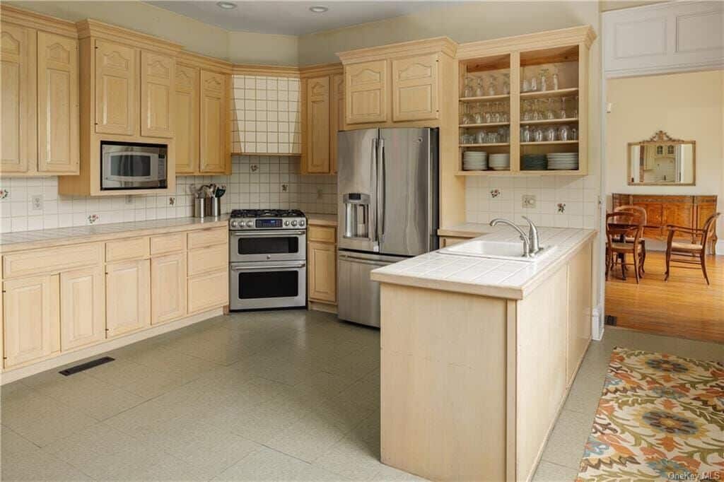 kitchen with pale wood cabinets and white tile countertop