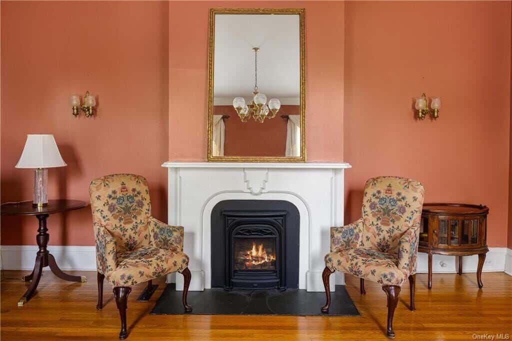 parlor with marble mantel and terra cotta colored walls