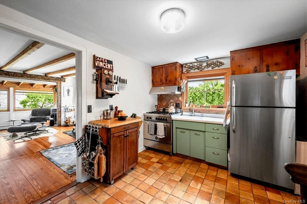 kitchen with terra cotta tile floor, vintage green sink cabinet