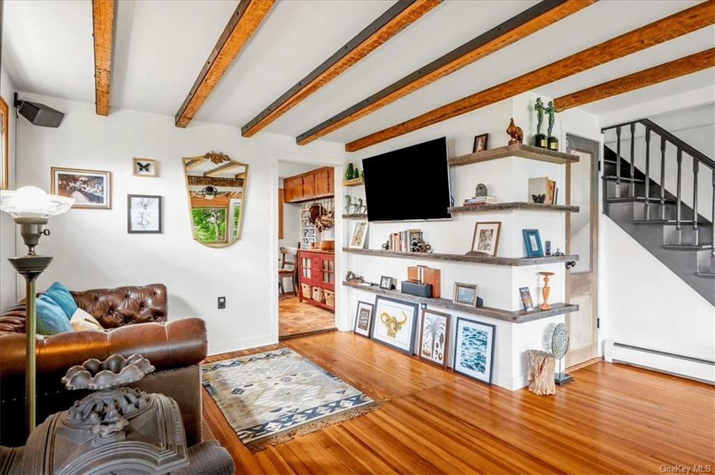 living room with beamed ceiling and baseboard heating