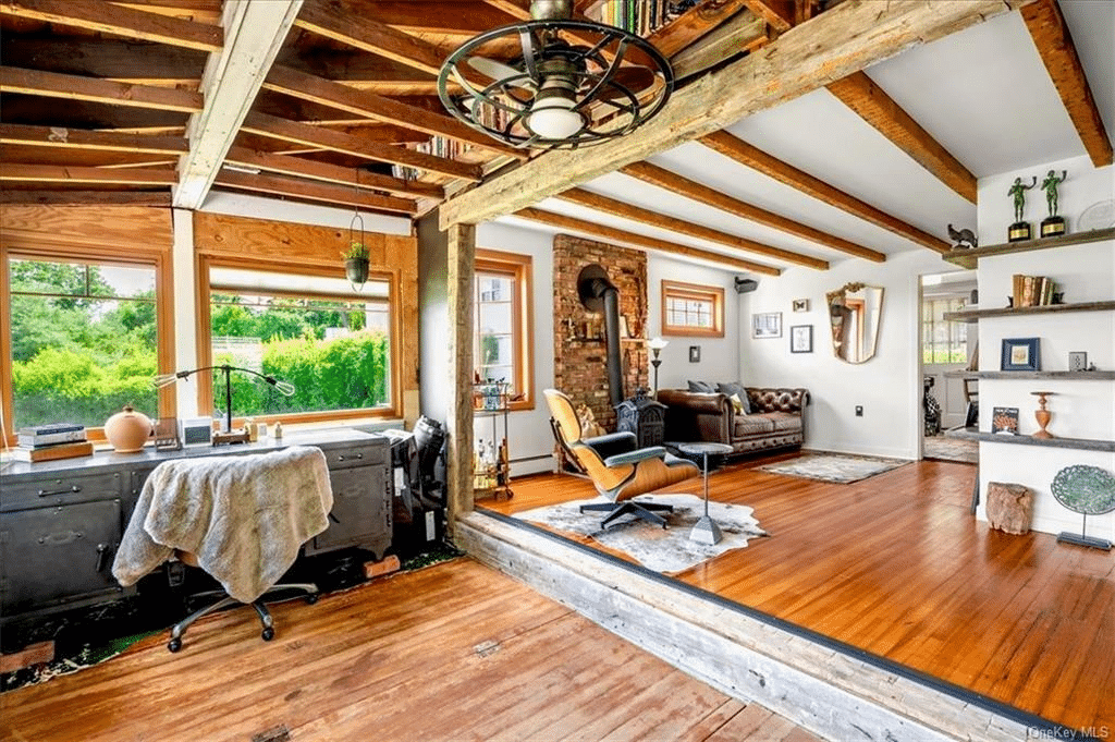 step up to living room with beamed ceiling