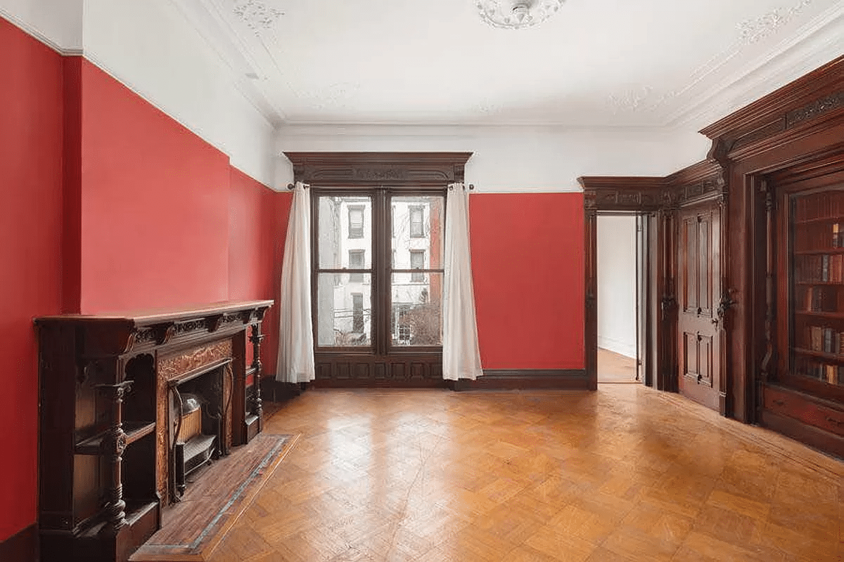 rear parlor with built-ins, wood mantel, and plaster details