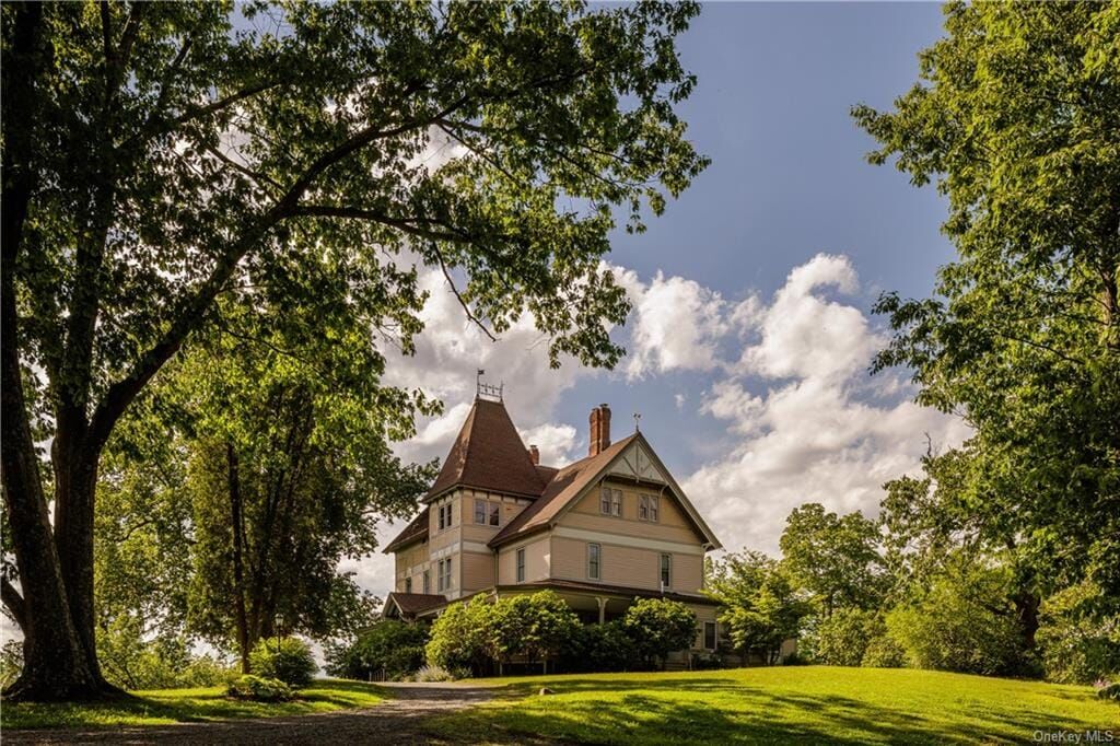 hudson -view of wooden villa with sloping lawn and shaded by large trees