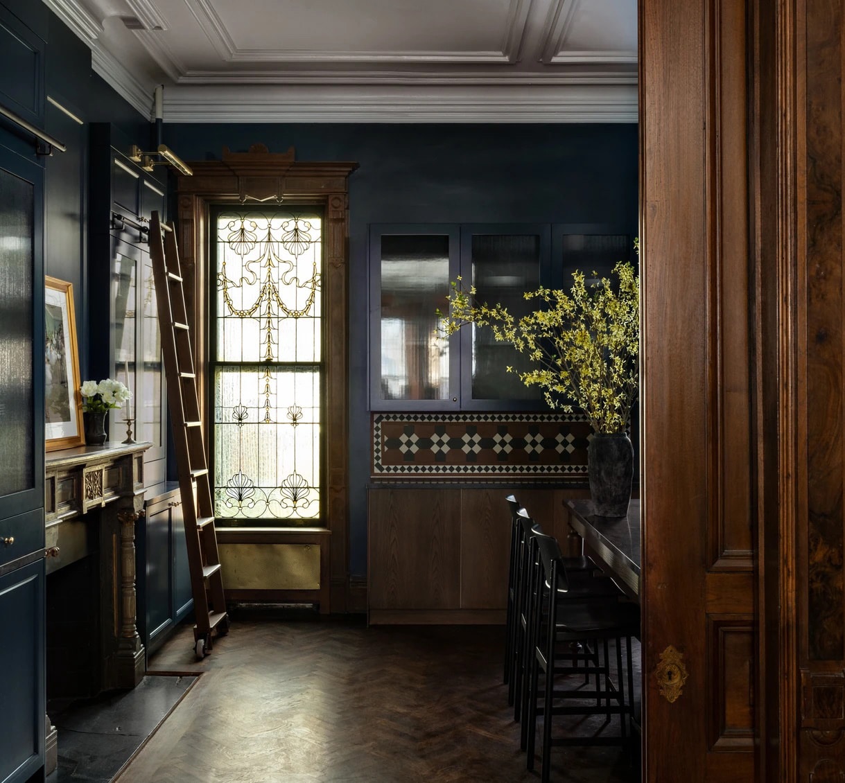 library ladder, mantel and dark blue walls in the kitchen