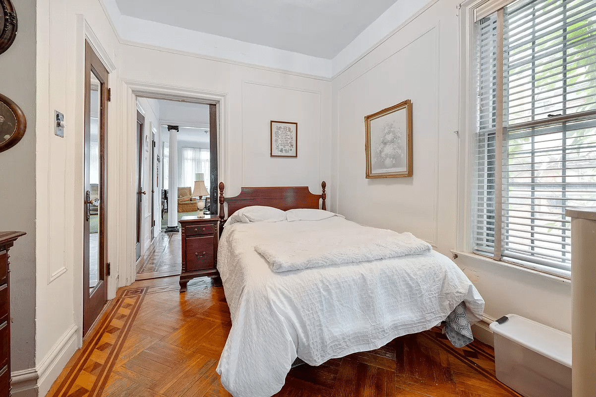 Bedroom with wall moldings, wooden floor