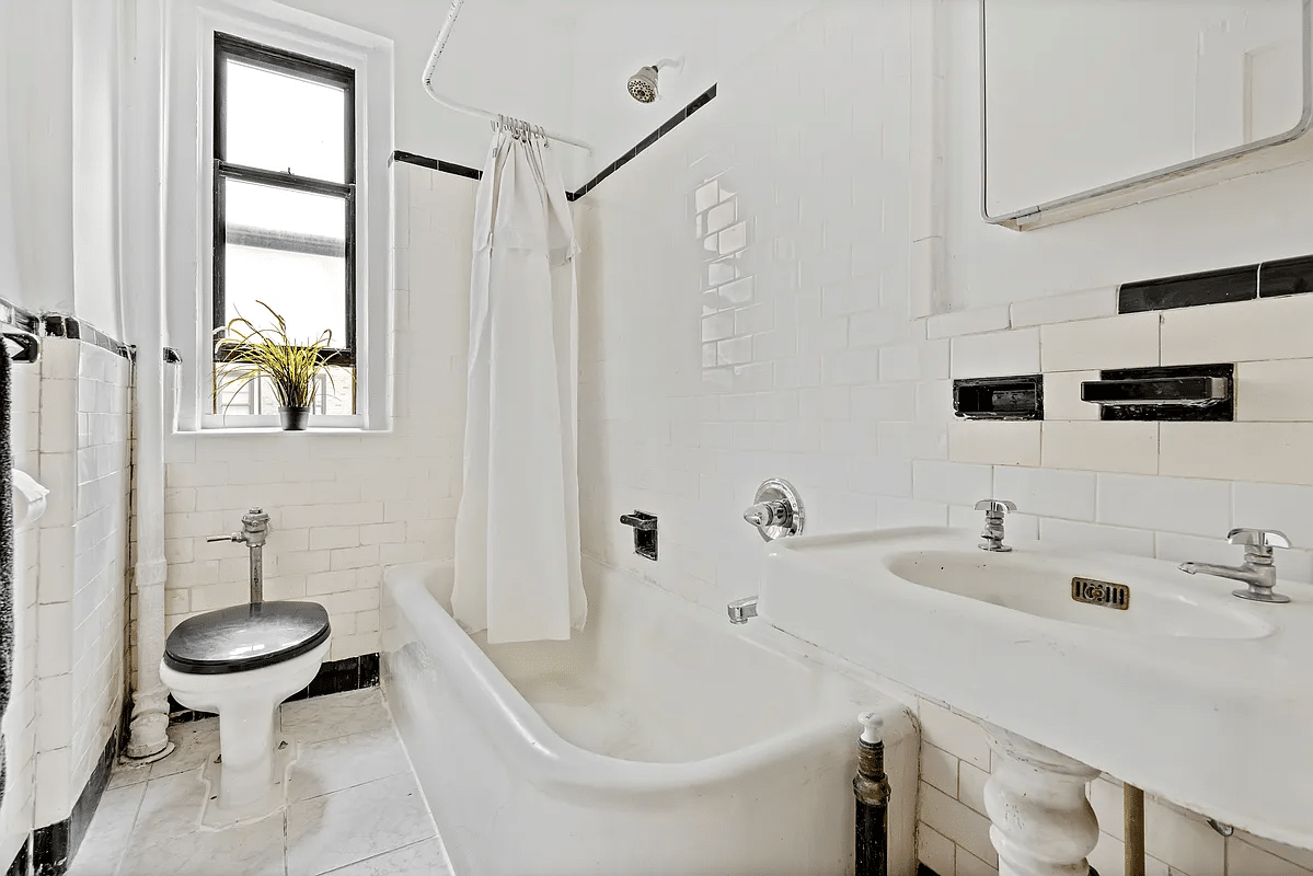 bathroom with white fixtures including a vintage tub