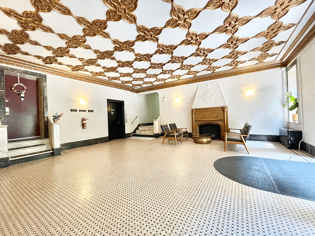 lobby with a mantel and an ornate gold ceiling