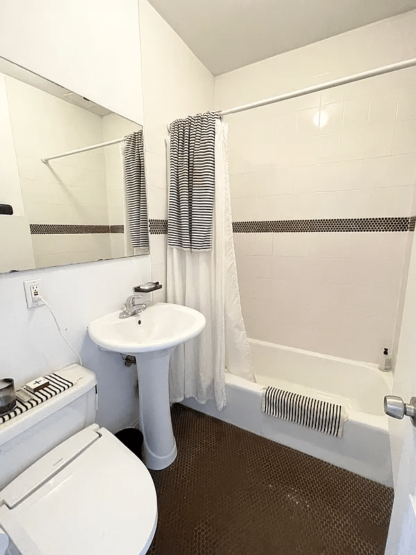 bathroom with white fixtures, black and white tile