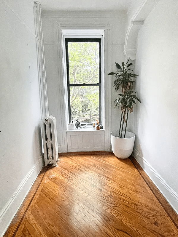 narrow bedroom with wood floor