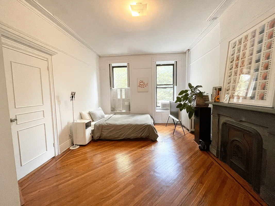 bedroom with mantel, picture rails, wood floor