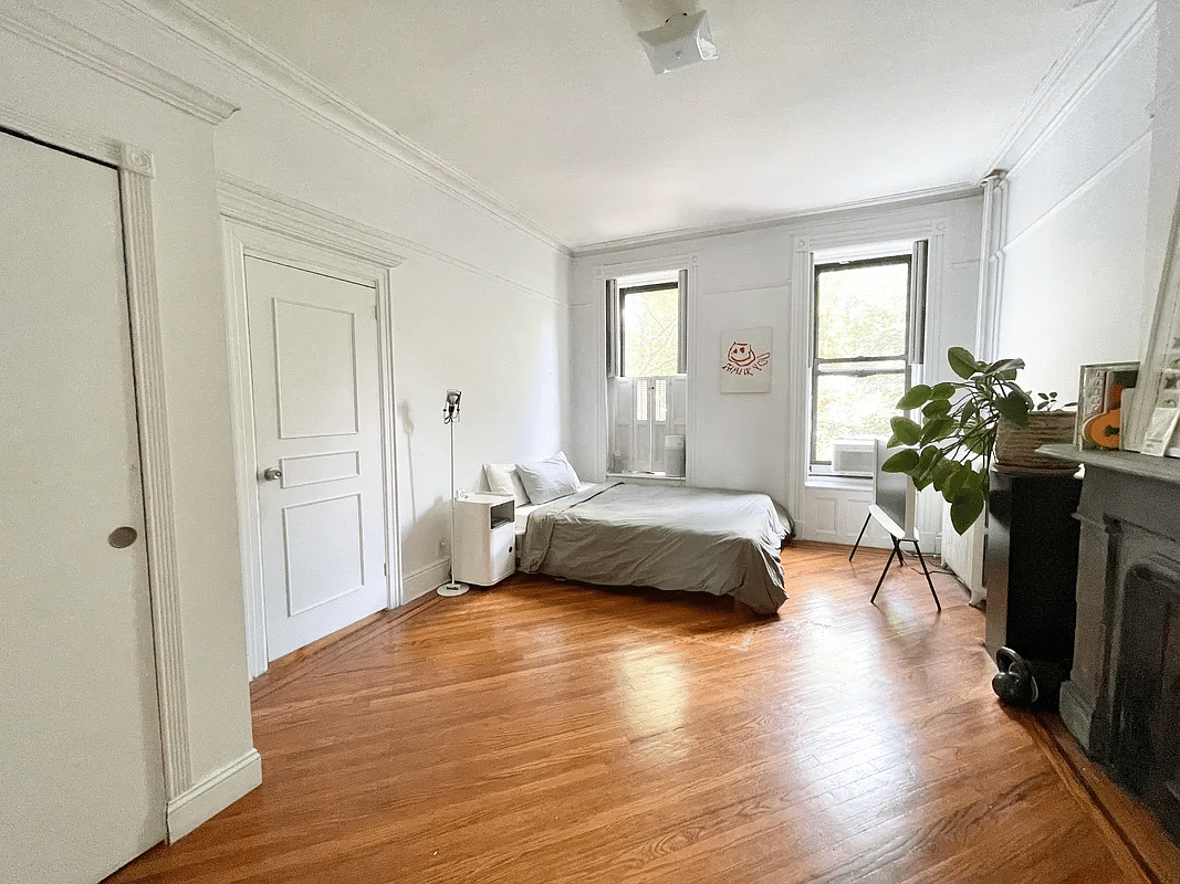 bedroom with mantel, picture rails, wood floor