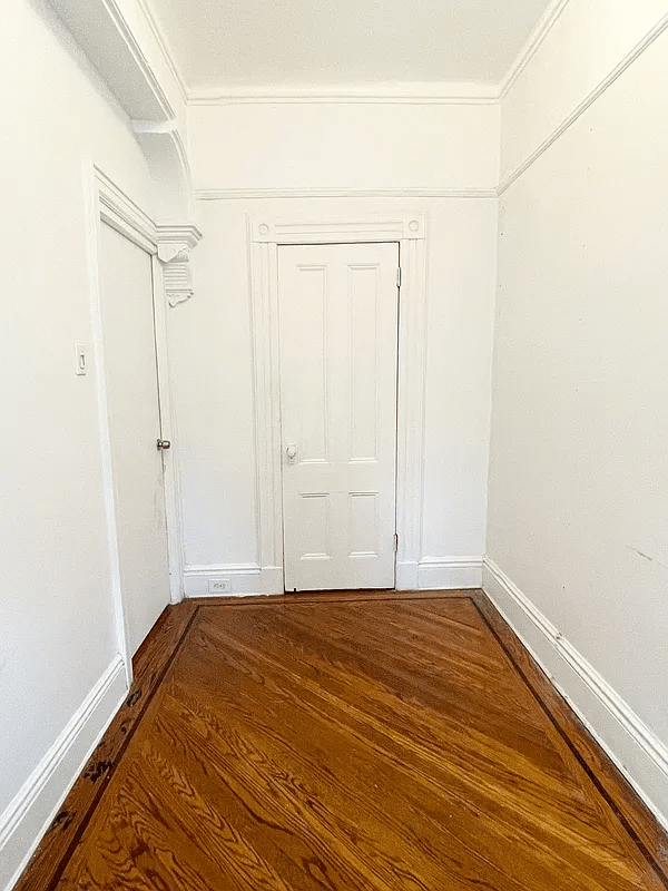 narrow bedroom with wood floor