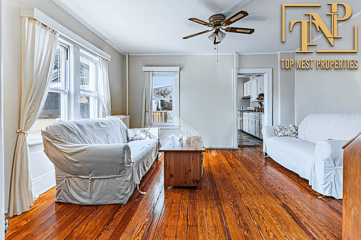 Dining room furnished as a living room with two exposures and view into the kitchen