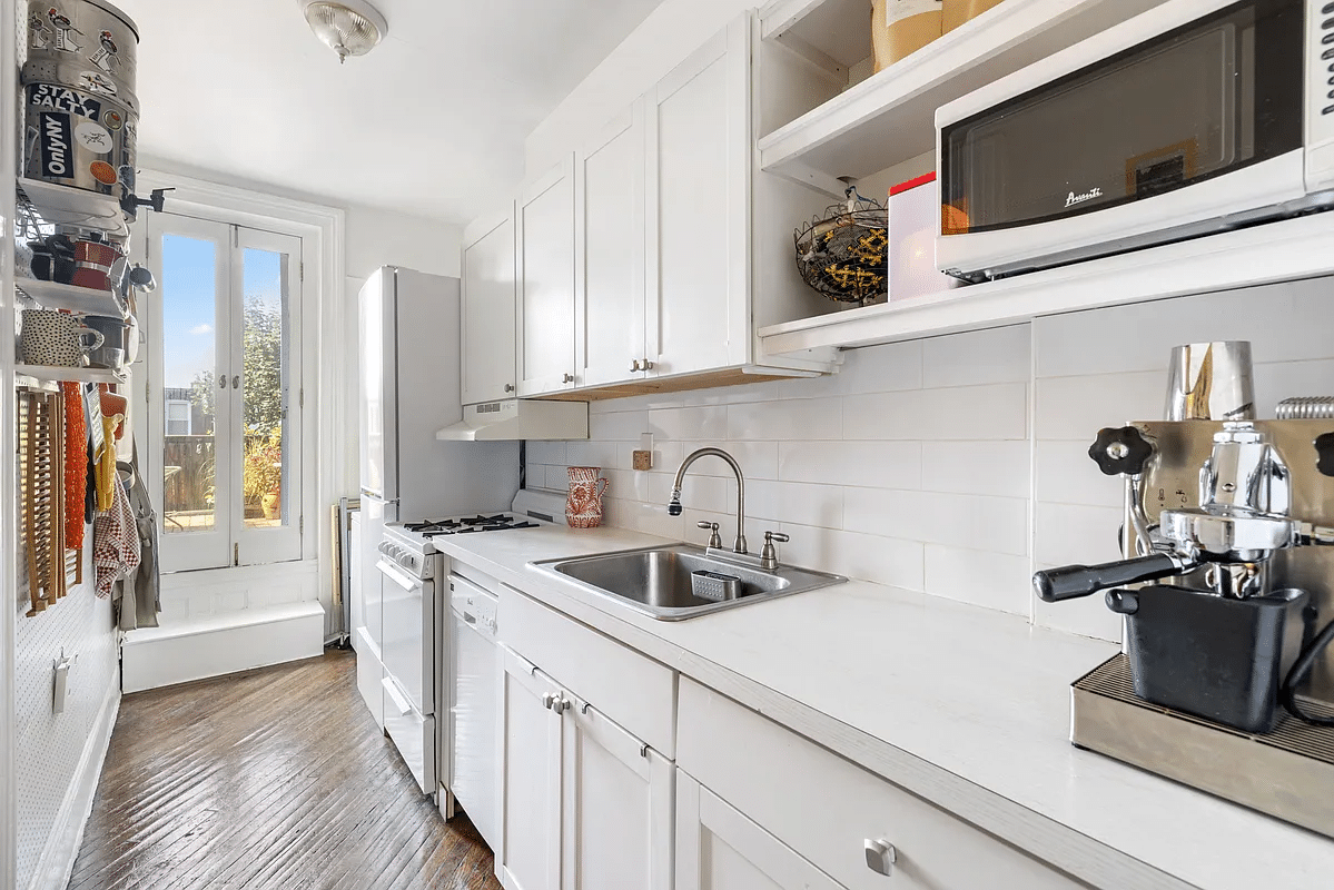 Galley kitchen with white cabinets