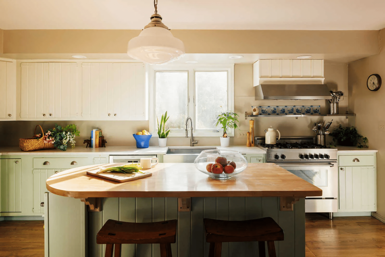 kitchen with wood topped island, pale green lower cabinets,