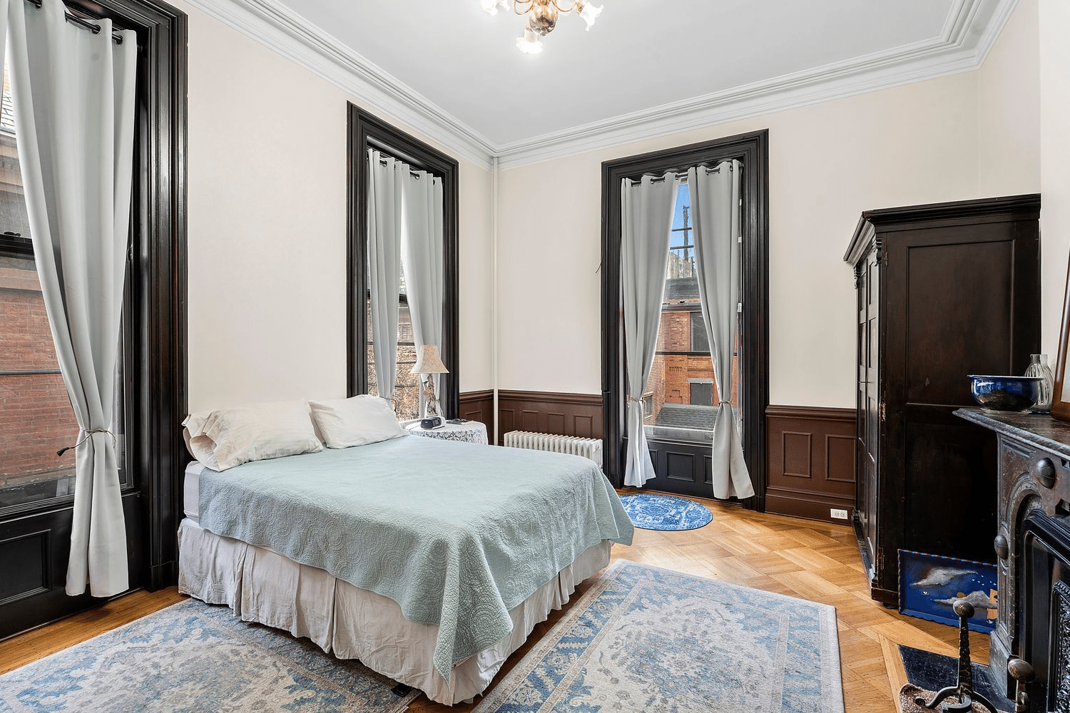 bedroom with wainscoting, wood floor