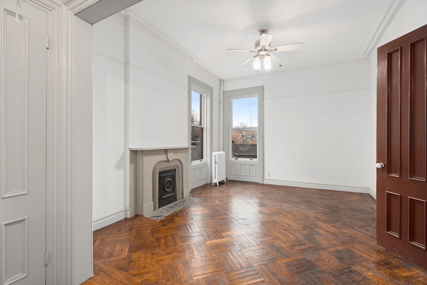 bedroom with wood floor, mantel, ceiling fan