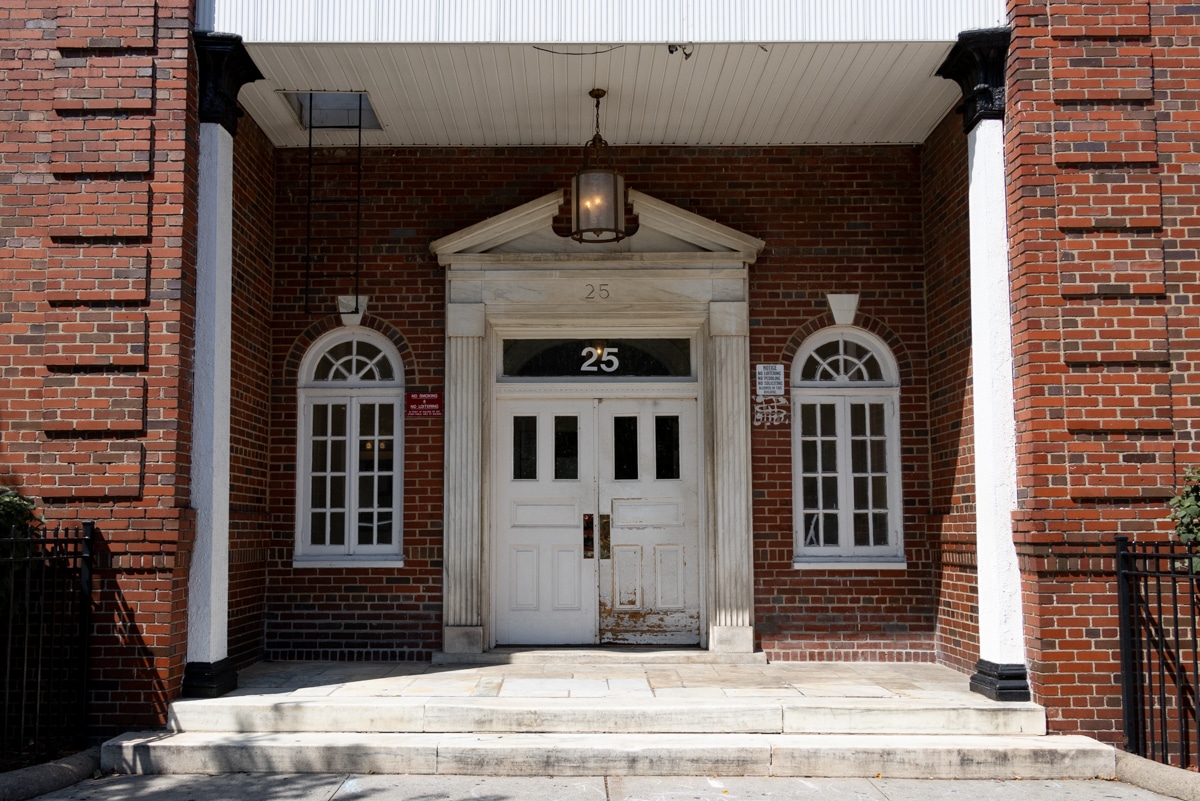 the colonial revival style entry to a brick apartment building