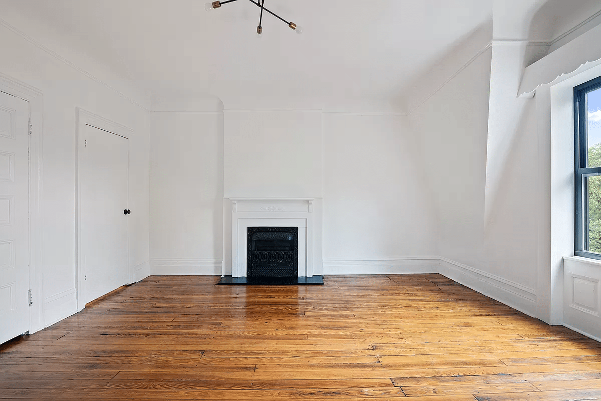 living room with wood floor and a mantel painted white