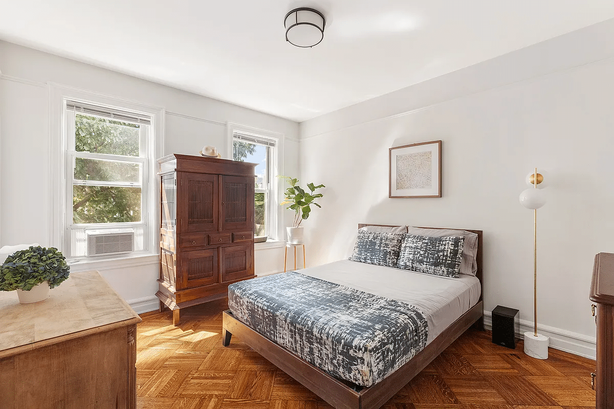 Bedroom with wooden floor, two windows