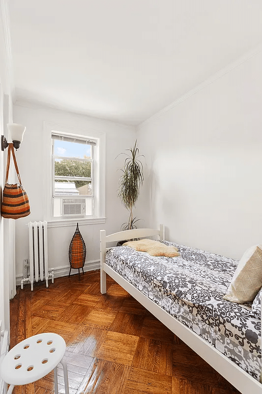 narrow bedroom with wooden floor