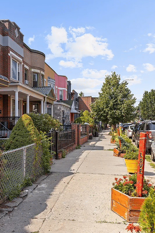 View of a row of houses and planters and trees on the sidewalk