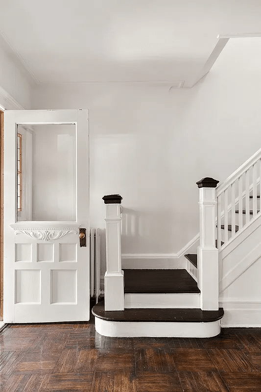 entry with white painted door and stair railing