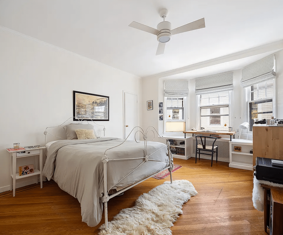 Bedroom with bay window, ceiling fan, wooden floor