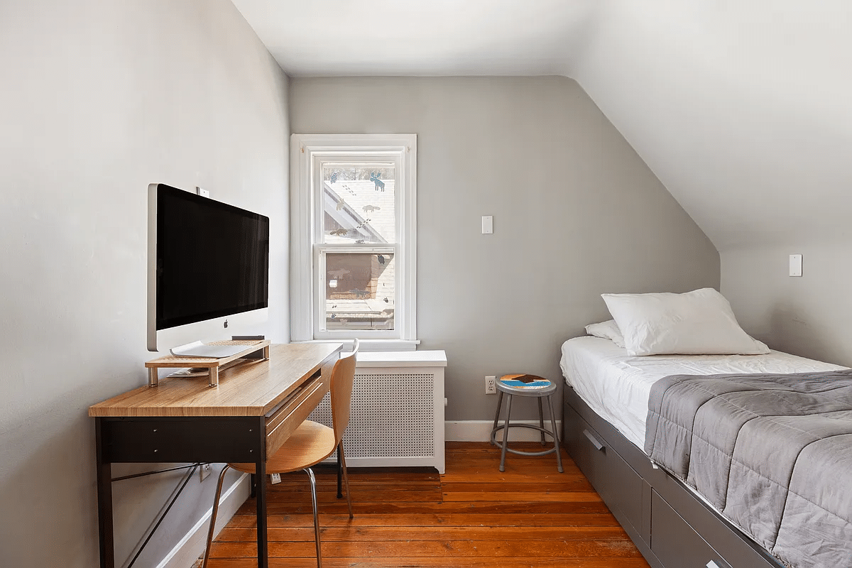 narrow bedroom with wooden floor, one window