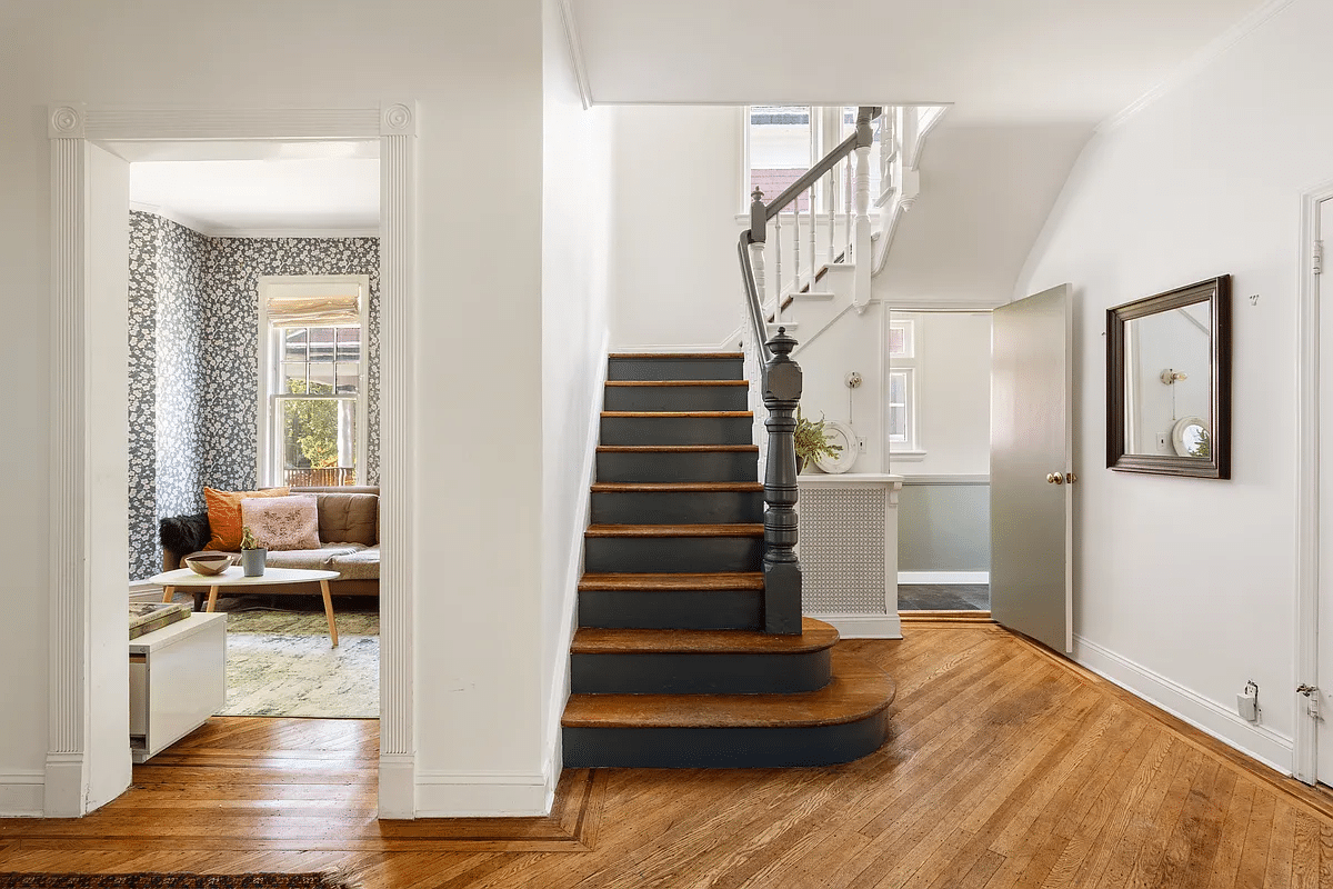 Entrance hall with view of stairs and blue wallpaper in library