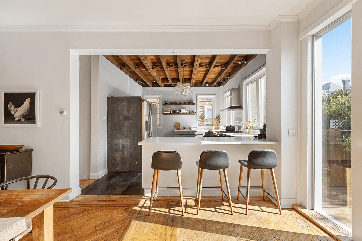 View into the kitchen with a white peninsula with seating